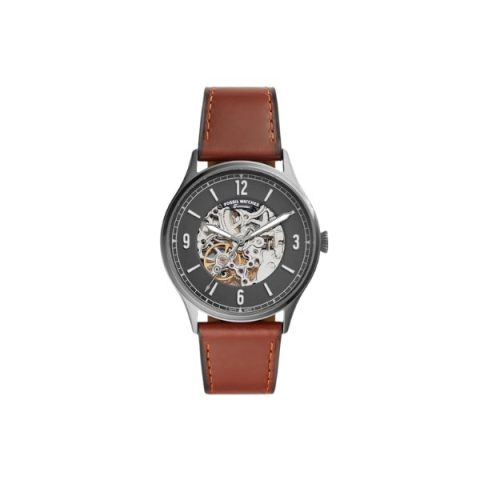 Reloj Fossil ME3178 con caja gris humo, esfera negra calada que deja ver el mecanismo y correa de cuero marrón, visto de frente